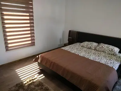 a bedroom with a bed and a window with sunlight at Apartman Ivona in Bar