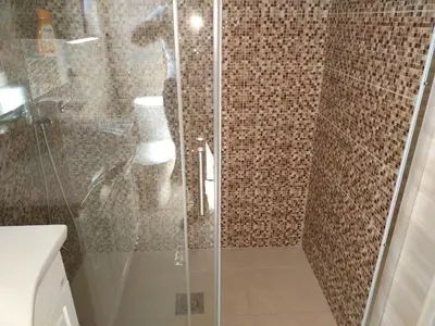 a bathroom with a glass shower with a toilet at Apartman Ivona in Bar