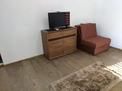 a living room with a television and a chair at Apartman Ivona in Bar