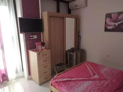a bedroom with a bed and a dresser and a television at Apartman Ivona in Bar