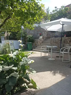 a patio with a table and chairs and an umbrella at Mini Garsonjera in Podgorica