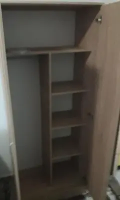 a closet with wooden shelves in a room at Mini Garsonjera in Podgorica