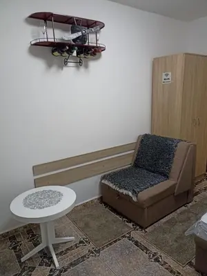 a chair and a table in a room at Mini Garsonjera in Podgorica