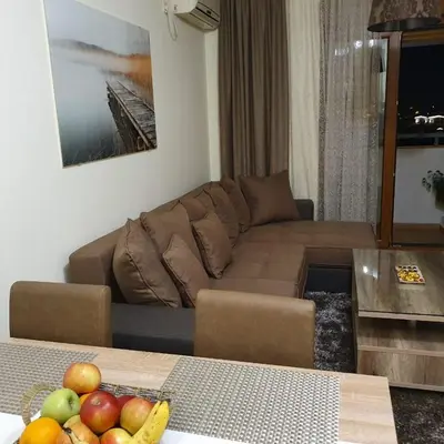 a living room with a couch and a table with fruits at Aphrodite Apartment in Podgorica