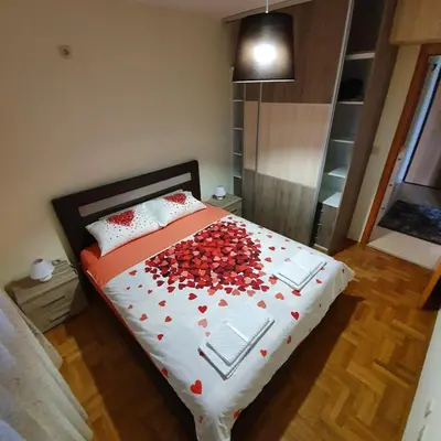 a bedroom with a bed with red hearts on it at Aphrodite Apartment in Podgorica