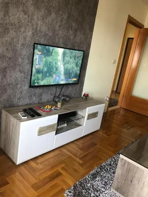 a living room with a television on a white entertainment center at Aphrodite Apartment in Podgorica