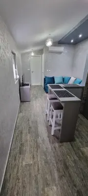 a living room with a table and blue couch at Amarok in Bar