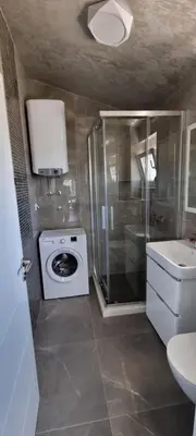 a bathroom with a washing machine and a sink at Amarok in Bar