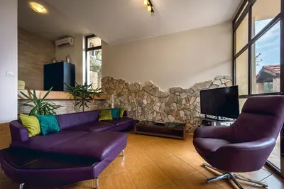a living room with a purple couch and two chairs at Villa Milana Budva in Budva