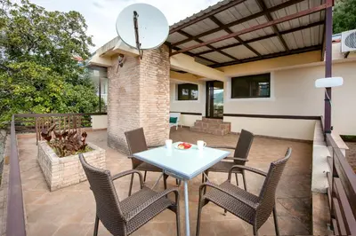 a patio with a white table and chairs at Villa Milana Budva in Budva