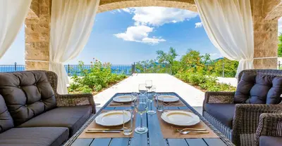 a wooden table with plates and silverware on it at Oak Leaf Residences in Budva