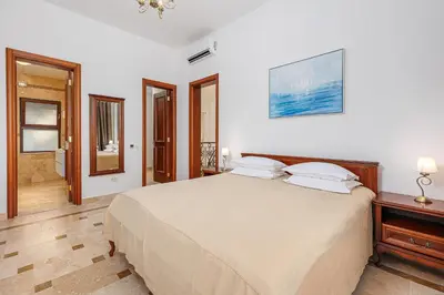 a bedroom with a large bed and a bathroom at Oak Leaf Residences in Budva