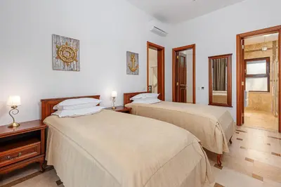 two beds in a room with two lamps at Oak Leaf Residences in Budva