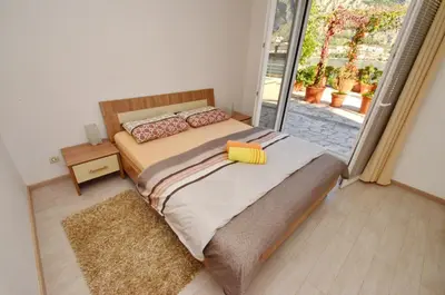 a bedroom with a bed and a large window at Muo Apartments in Kotor