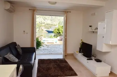 a living room with a couch and a large window at Muo Apartments in Kotor