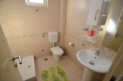 a small bathroom with a toilet and a sink at Muo Apartments in Kotor