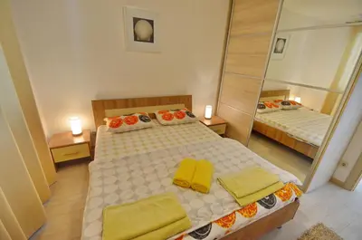a bedroom with two beds and a large mirror at Muo Apartments in Kotor