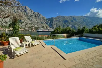 a swimming pool with two lounge chairs next to aretched at Muo Apartments in Kotor
