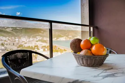 a basket of fruit on a table with a view at Harmonia Panorama Apartments in Budva