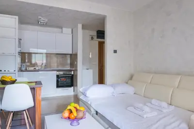 a living room with a couch and a table with a bowl of fruit at Harmonia Panorama Apartments in Budva