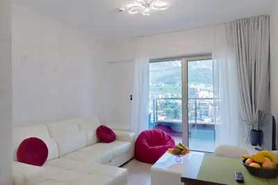 a living room with a white couch and pink pillows at Harmonia Panorama Apartments in Budva