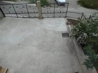 a concrete patio with a fence in a yard at Green Line Guesthouse in Bar