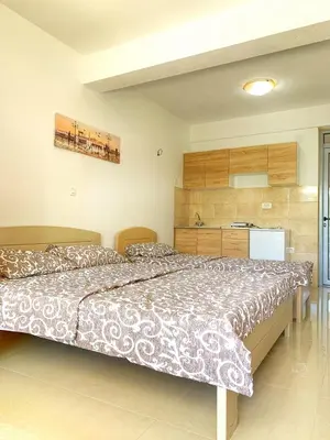 a bedroom with a large bed and a refrigerator at Apartment kalina in Bar