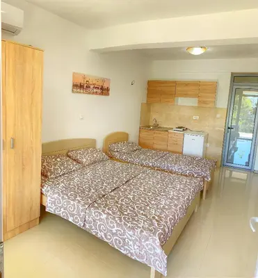 a bedroom with two beds and a kitchen in it at Apartment kalina in Bar