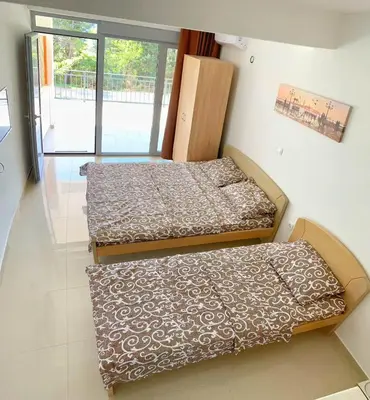two beds sitting in a room with a window at Apartment kalina in Bar