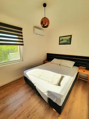 a bedroom with a large bed and a window at Montenegro Sea Pearl Apartments Petrovac in Petrovac na Moru
