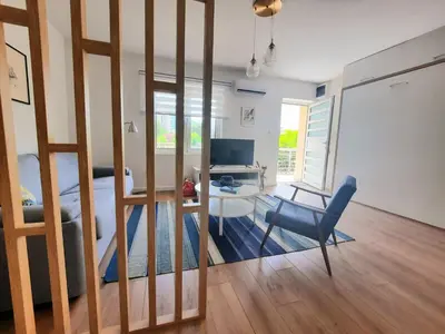 a living room with a bed and a desk and a chair at Montenegro Sea Pearl Apartments Petrovac in Petrovac na Moru