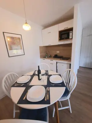 a dining room table with chairs and a kitchen at Montenegro Sea Pearl Apartments Petrovac in Petrovac na Moru