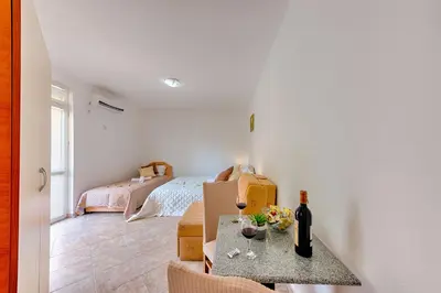 a room with a bed and a table with wine bottles at HOTEL DANA in Čanj
