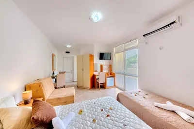 a bedroom with two beds and a living room at HOTEL DANA in Čanj