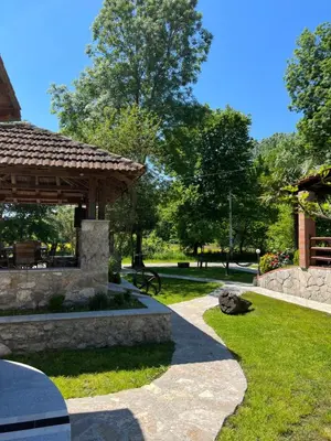 a garden with a stone pavilion and a park at Forest Home in Golubovci