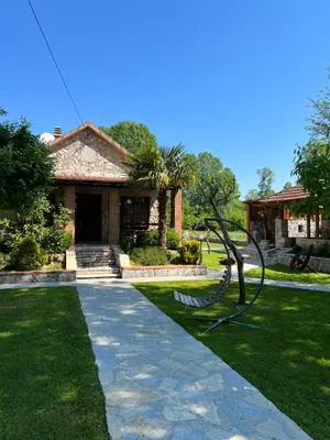 a house with a statue in front of a yard at Forest Home in Golubovci
