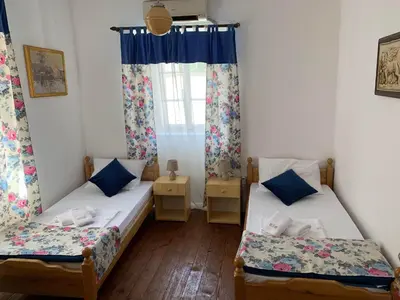 two beds in a room with a window at Viktor Rooms in Kotor