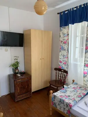 a bedroom with a bed and a cabinet and a chair at Viktor Rooms in Kotor