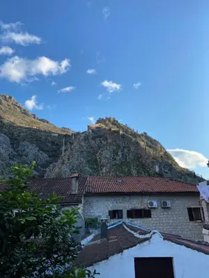 a building with a mountain in the background at Viktor Rooms in Kotor