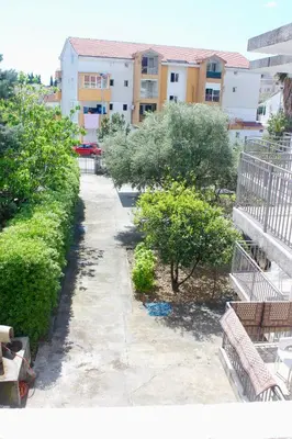 a view of a courtyard with benches and trees at Nir Apartments Budva in Budva