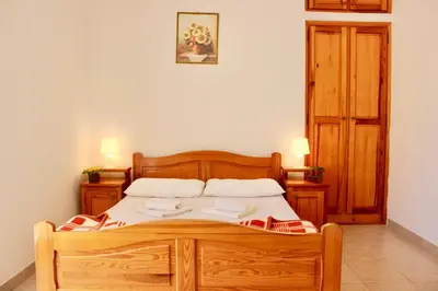 a bedroom with a wooden bed with two pillows at Nir Apartments Budva in Budva