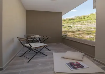 a room with a table and chairs and a window at Twins in Rafailovici