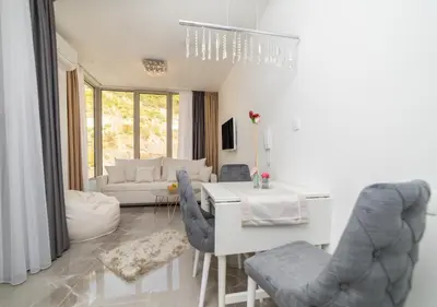 a living room with a white table and chairs at Twins in Rafailovici