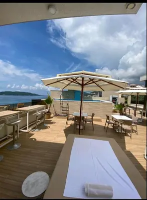 a deck with tables and chairs and an umbrella at Twins in Rafailovici
