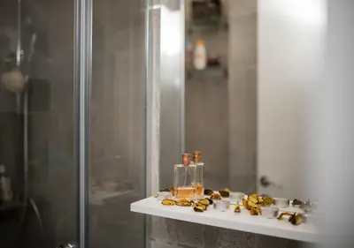 a bathroom with a shower and a shelf with candles at Twins in Rafailovici