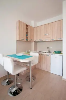 a kitchen with a table and chairs and a sink at Premium Lea Apartments in Ulcinj