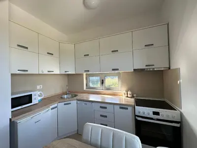 a kitchen with white cabinets and white appliances at Premium Lea Apartments in Ulcinj