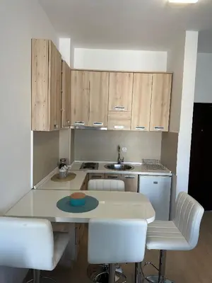 a kitchen with wooden cabinets and a table and chairs at Premium Lea Apartments in Ulcinj