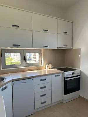 a white kitchen with white cabinets and a stove at Premium Lea Apartments in Ulcinj