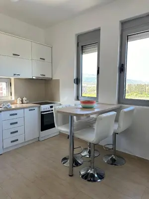 a kitchen with a table and chairs in a room at Premium Lea Apartments in Ulcinj